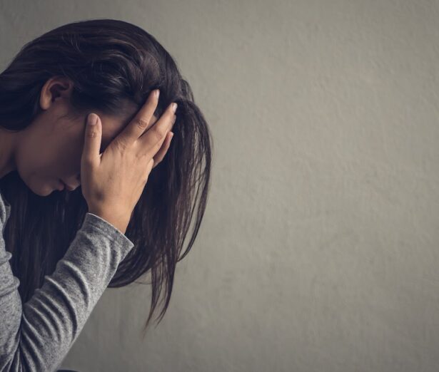 Depressed woman sitting on a chair in dark room at home. Lonly , sad, emotion concept.